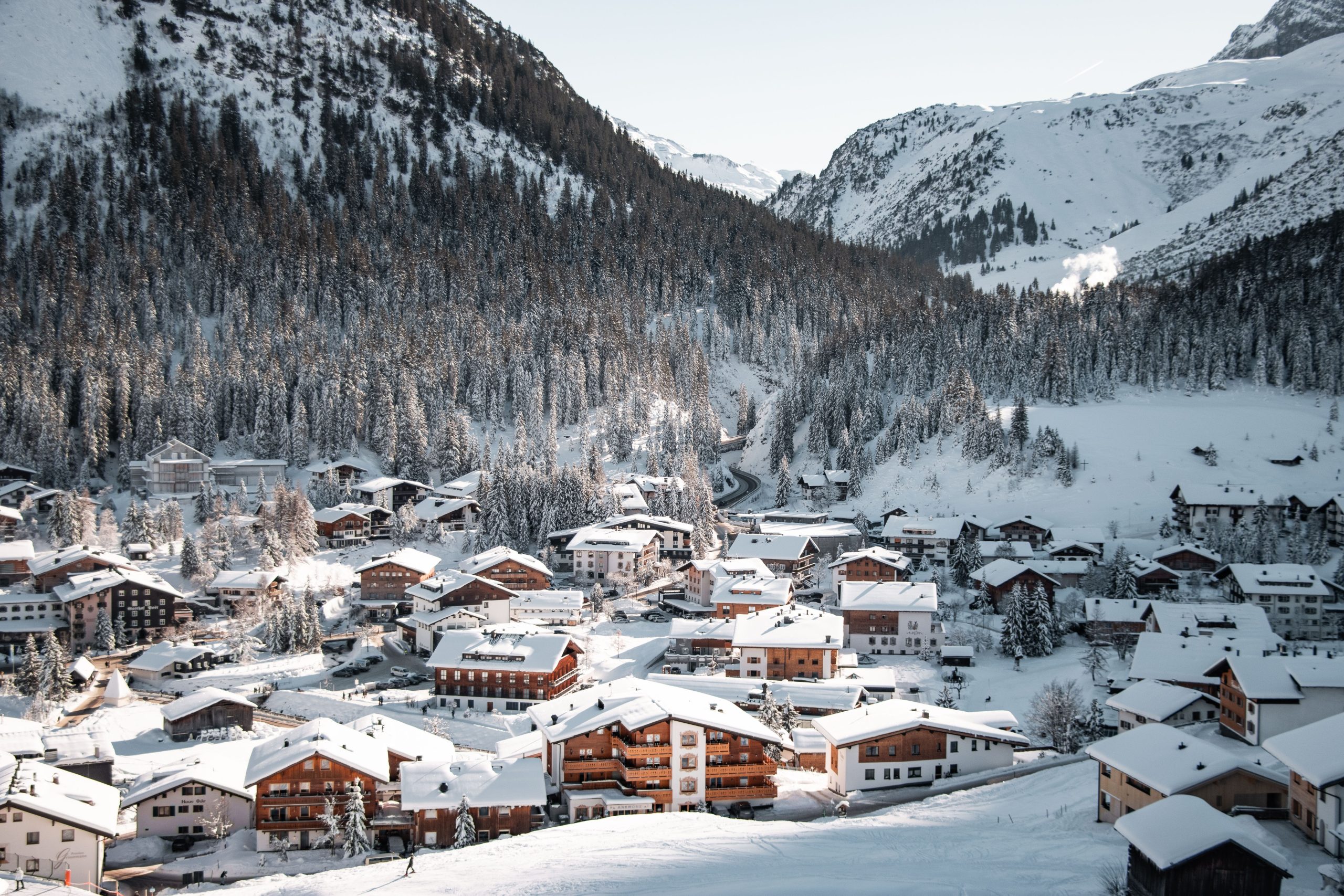 Scenic view of snow-covered village in Lech am Arlberg, Austria with mountains.